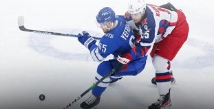 Хоккеисты в бело-голубой и бело-красной форме борются за шайбу на ледовой арене. Один пытается отобрать у другого, поддерживая клюшкой. На льду видна черная шайба